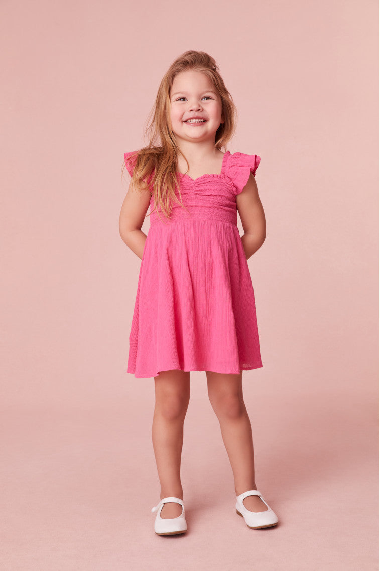 Girls mini dress featuring flutter sleeves and ruffle detail.