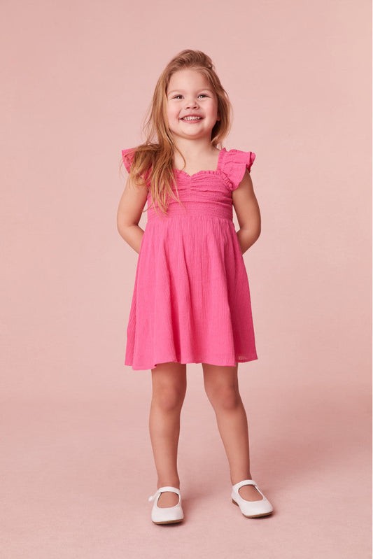 Girls mini dress featuring flutter sleeves and ruffle detail.